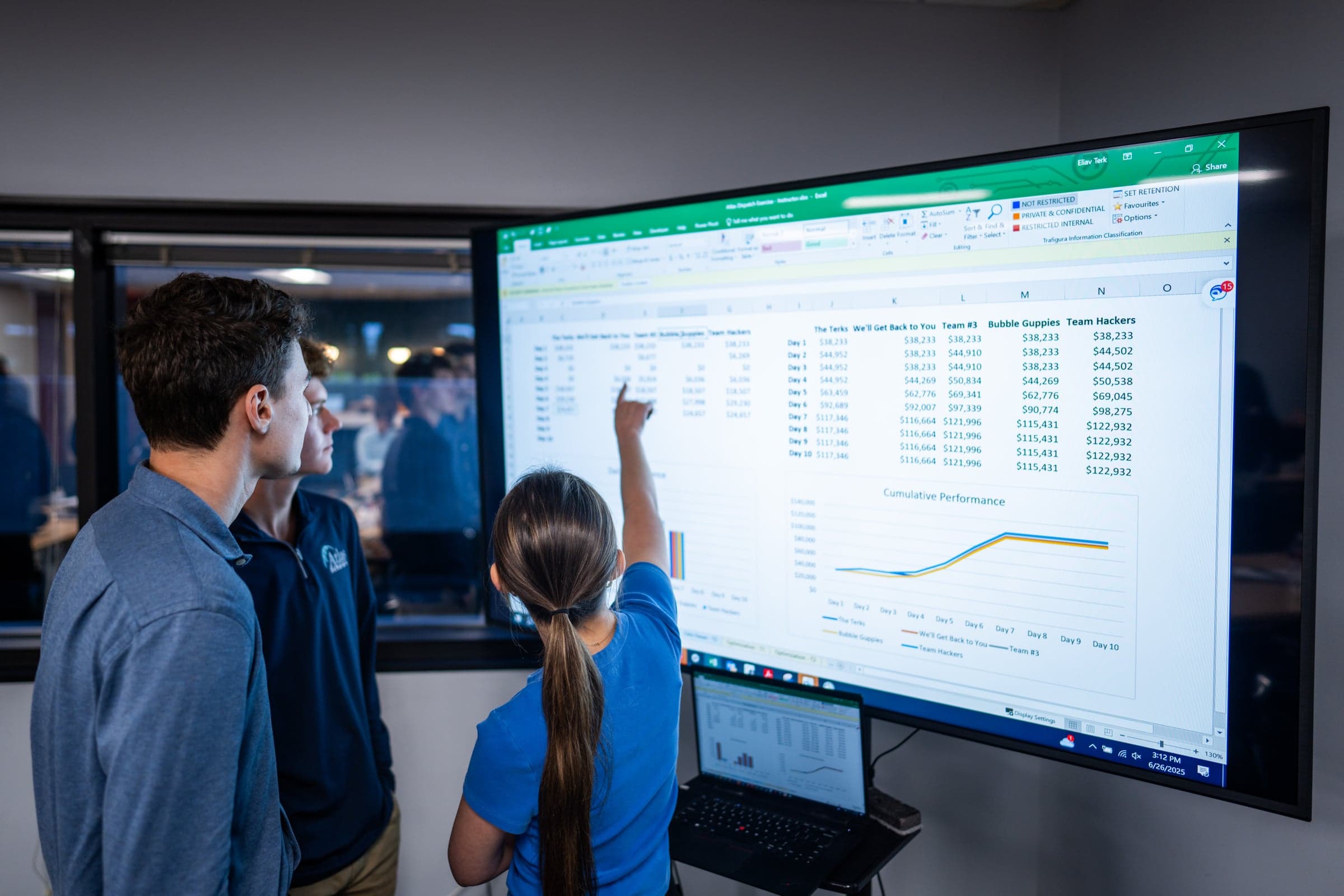An Atlas Scholar points out her team's results on a performance dashboard during a summer project
